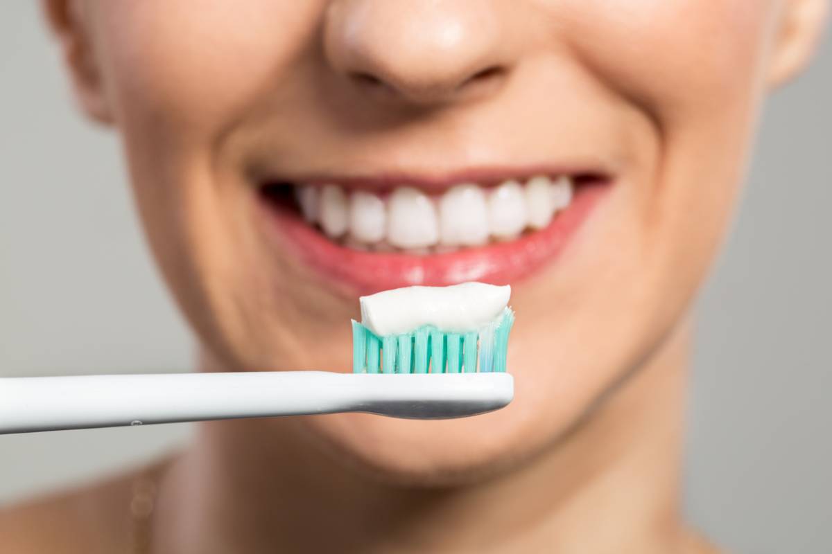 Woman brushing teeth following tips for keeping implants clean